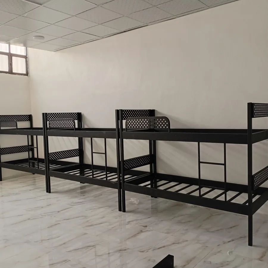 Rows of metal bunk beds in a dormitory room
