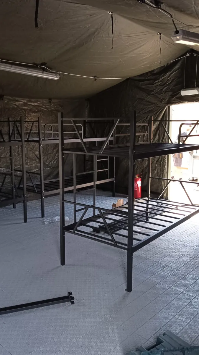 Black metal bunk beds set up at a field camp