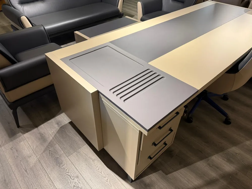 Close view of the raised pen tray on the desk top, with its recess and grooves