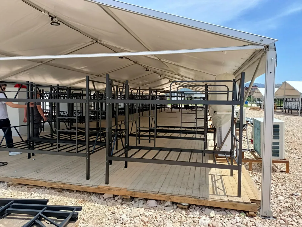 Bunk bed frames part-assembled on a tent deck
