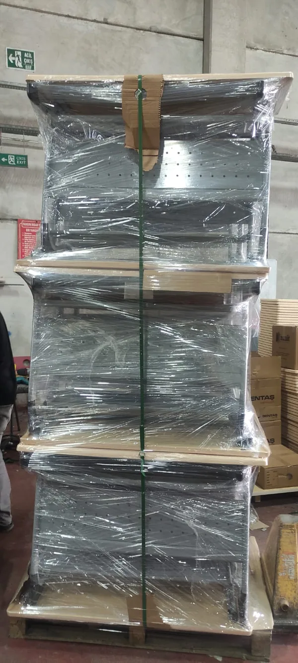 Three pallets of school desk and chair sets stacked three high, stretch wrapped with green strapping
