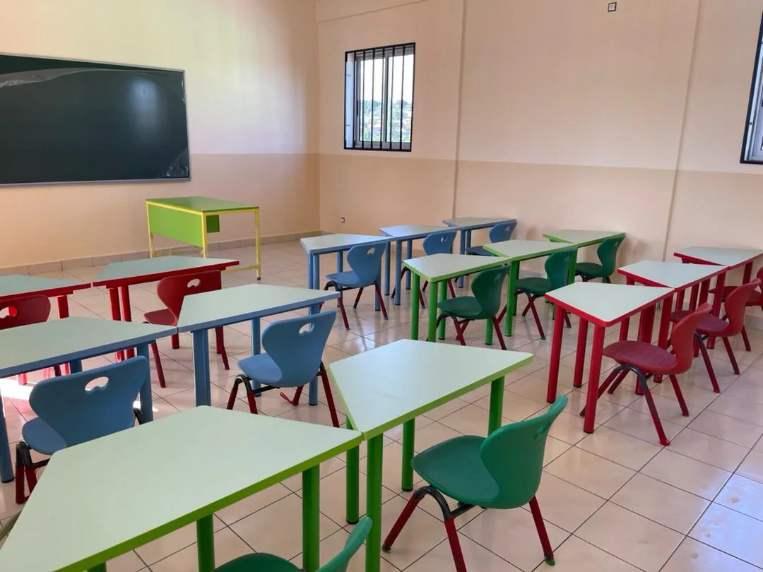 Trapezoid tables grouped in pairs with school chairs in a classroom