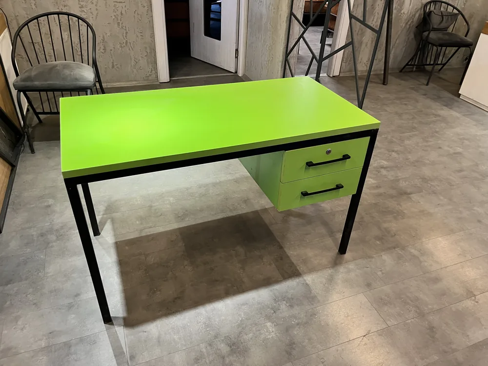 Teacher desk with a green top and drawer front on a black steel frame