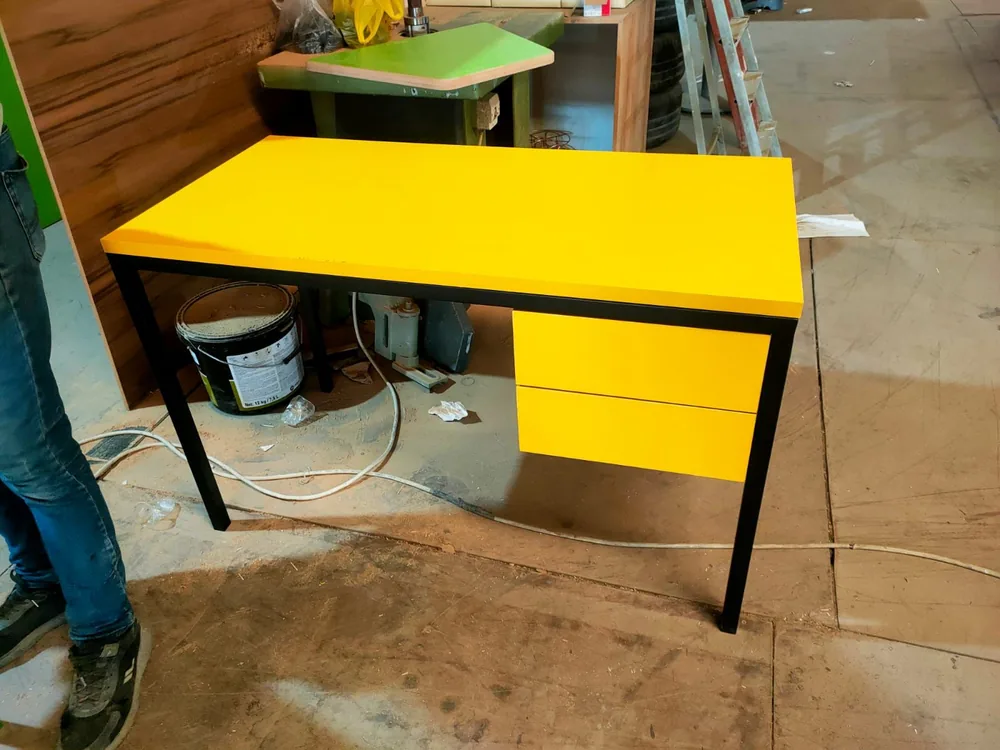 Teacher desk with a yellow top and drawer front on a black steel frame