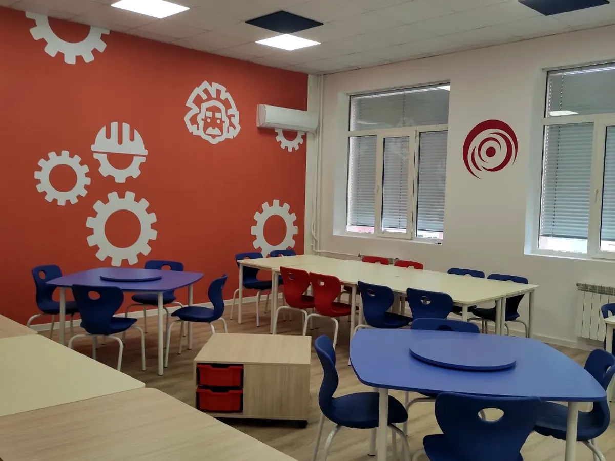 Blue stackable school chairs around classroom tables in a primary school room
