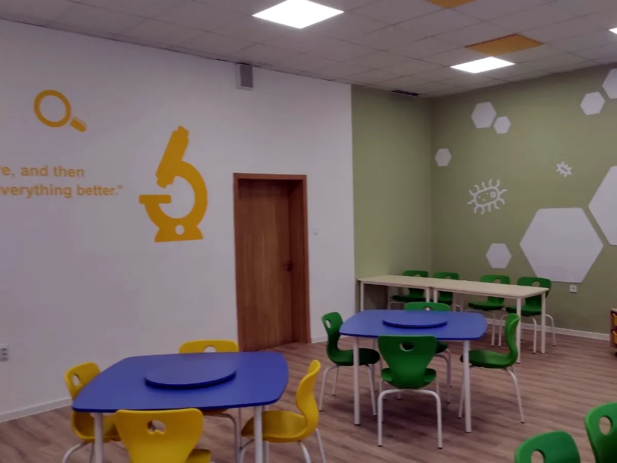 Yellow and green stackable school chairs around a group table in a science classroom