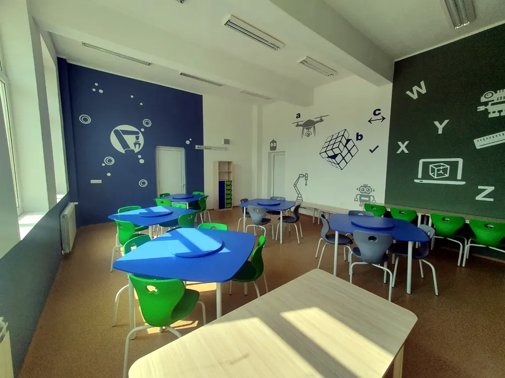 Green and blue stackable school chairs around classroom tables in a science room